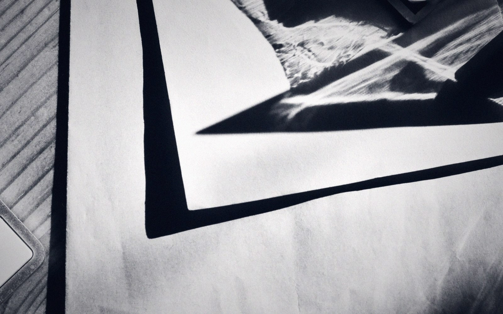 Corner of a printed black-and-white abstract design resting on a wooden surface