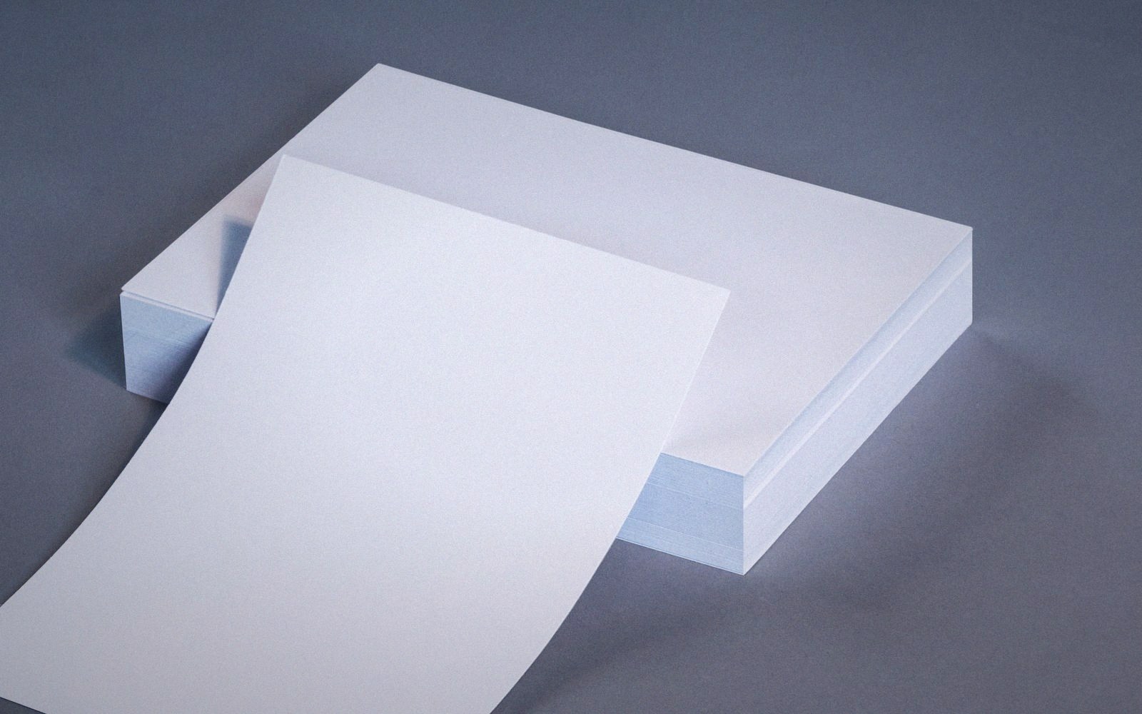 A blank sheet peeling off the top of a stacked ream of paper