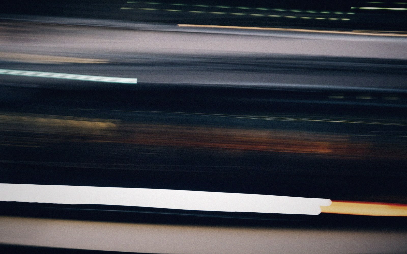 Motion-blurred streaks of light and pavement markings from a moving vehicle at speed