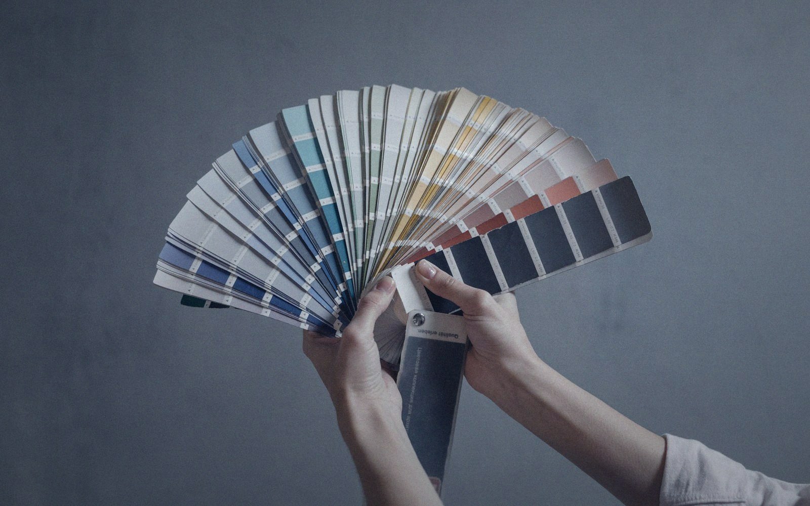 A fanned colour swatch book under a lamp